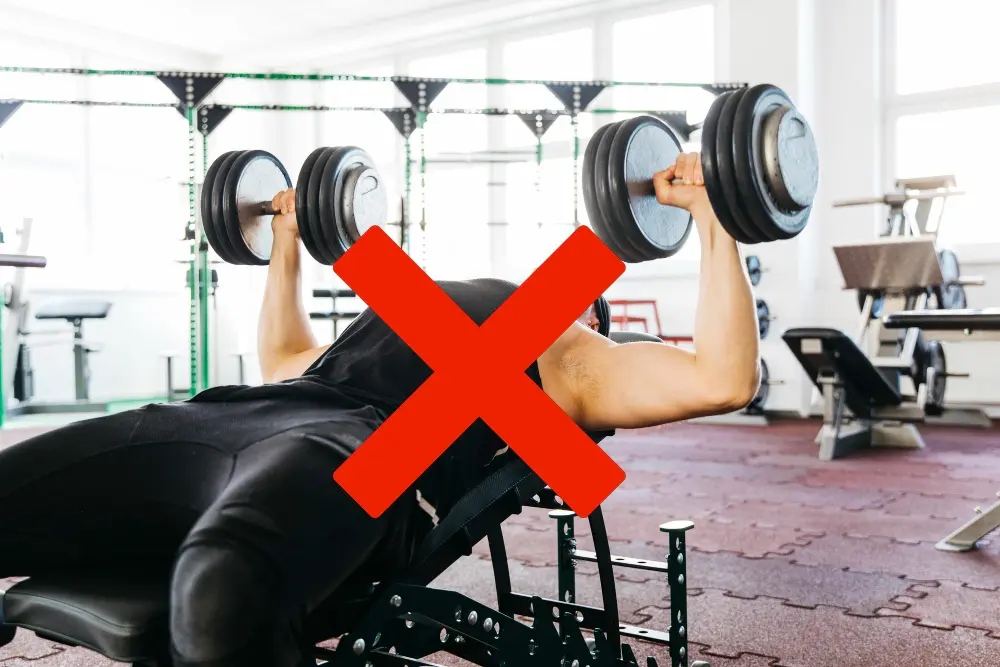 重たいダンベルを持つ男性にバッテンマーク